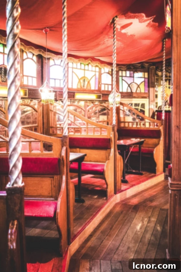 Interior view of Musee des Arts Forains in Paris, showing classic red seats and antique fairground decor.