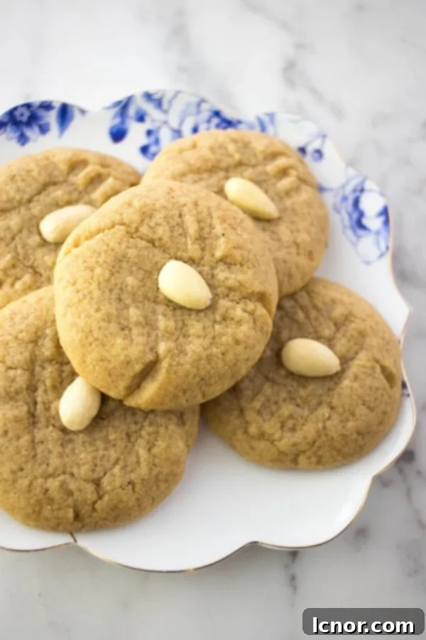 A beautifully arranged plate of golden-brown almond butter cookies, showcasing their inviting texture.