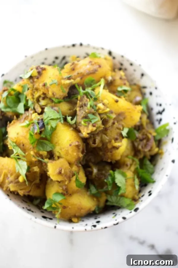 a bowl filled with spiced Indian Bombay potatoes and topped with cilantro