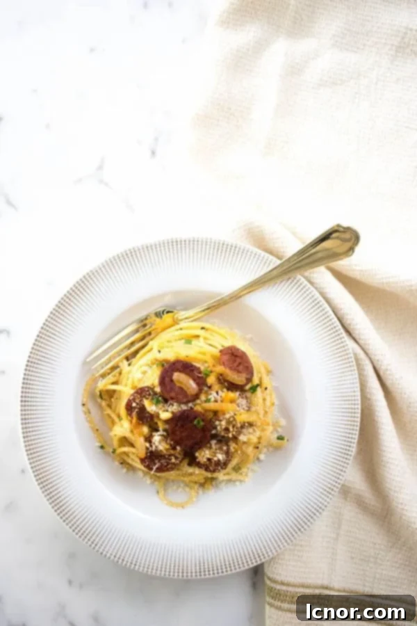 A beautifully presented bowl of creamy chorizo spaghetti, garnished with fresh chives and grated parmesan, ready to be enjoyed.
