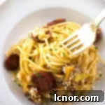 a gold fork in creamy chorizo pasta