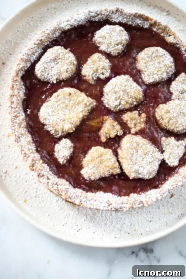 a rhubarb and oatmeal cake on a cream plate, garnished with powdered sugar.