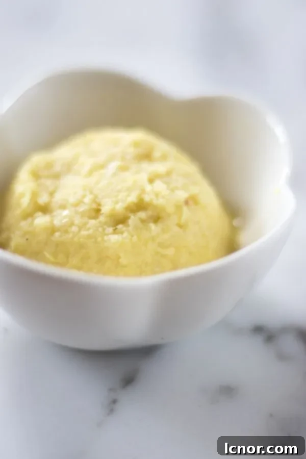 garlic ginger paste in a small white porcelain bowl on a white marble table