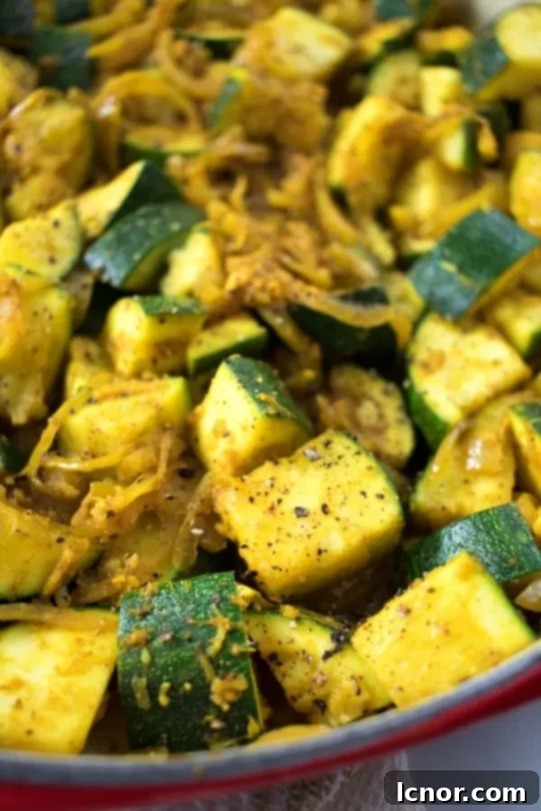 A close-up shot of Indian zucchini curry, highlighting the vibrant green zucchini pieces and rich spice blend.