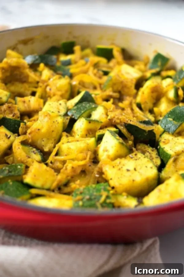 Indian zucchini curry presented beautifully in a red Le Creuset dish, ready to be served.