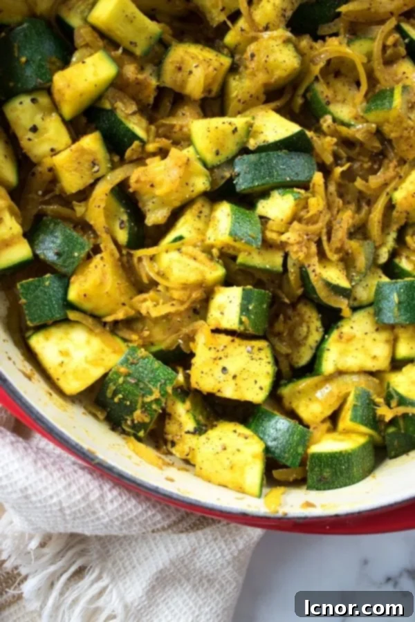 Indian Zucchini Curry in a serving bowl, garnished with fresh herbs, ready to be enjoyed.