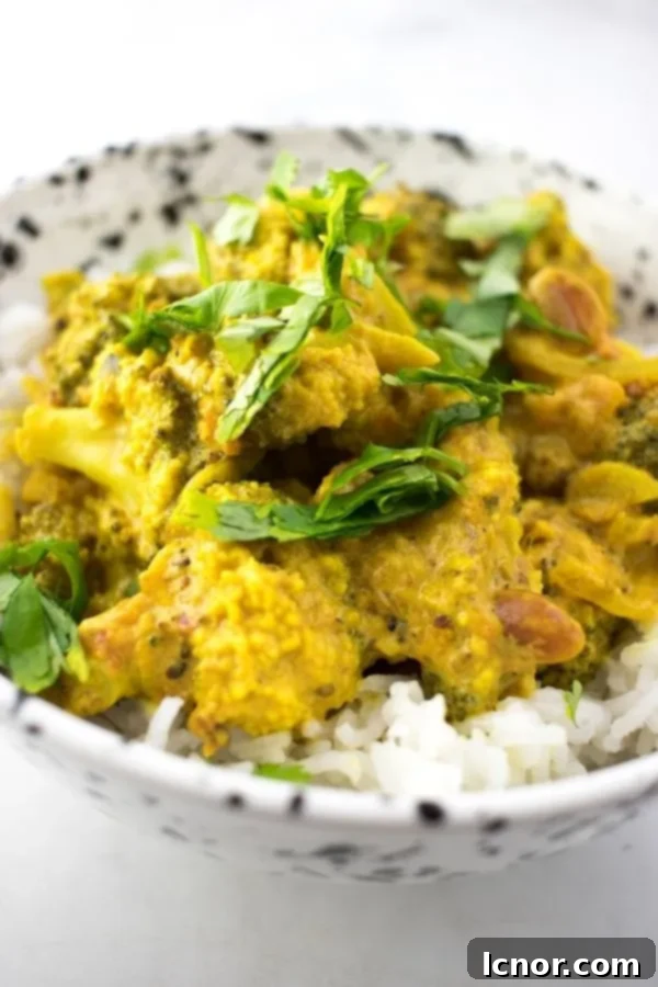 Indian broccoli curry topped with fresh cilantro in a white and black speckled bowl