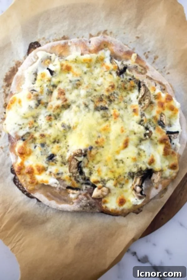 sourdough pizza with cheese and mushrooms on a wooden board