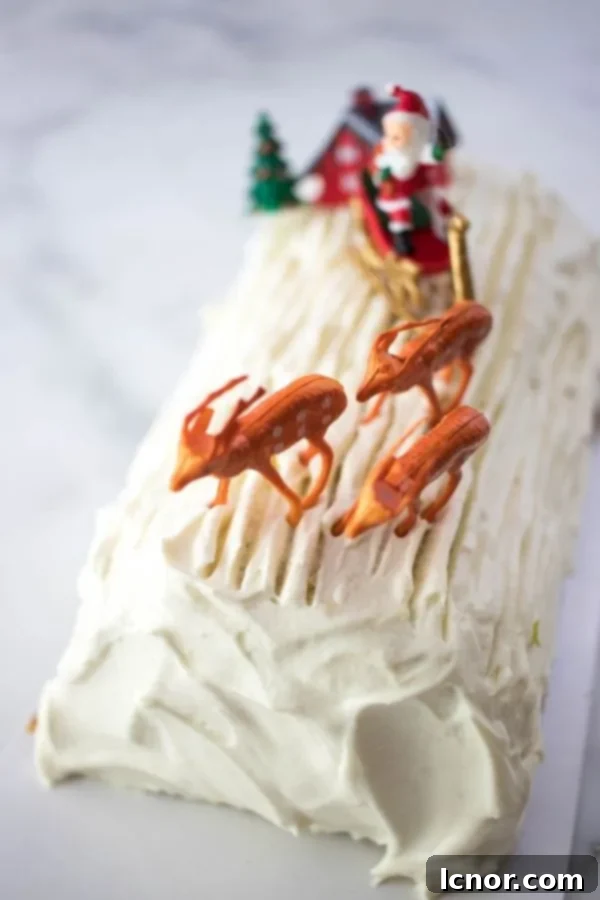 white French Buche de Noel topped with icing, Santa Claus and some deer