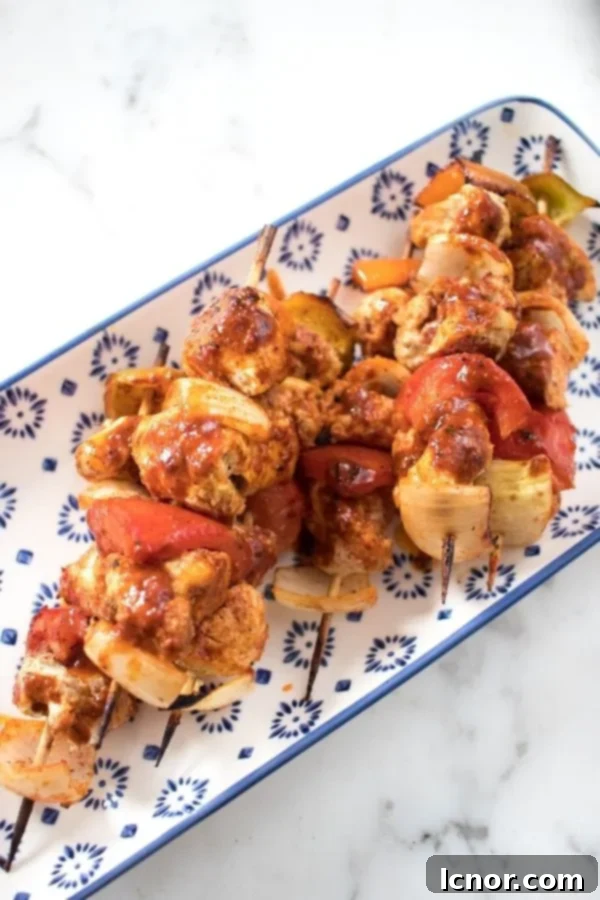 Succulent chicken kabobs baked to perfection in the oven, displayed on a vibrant blue and white serving tray