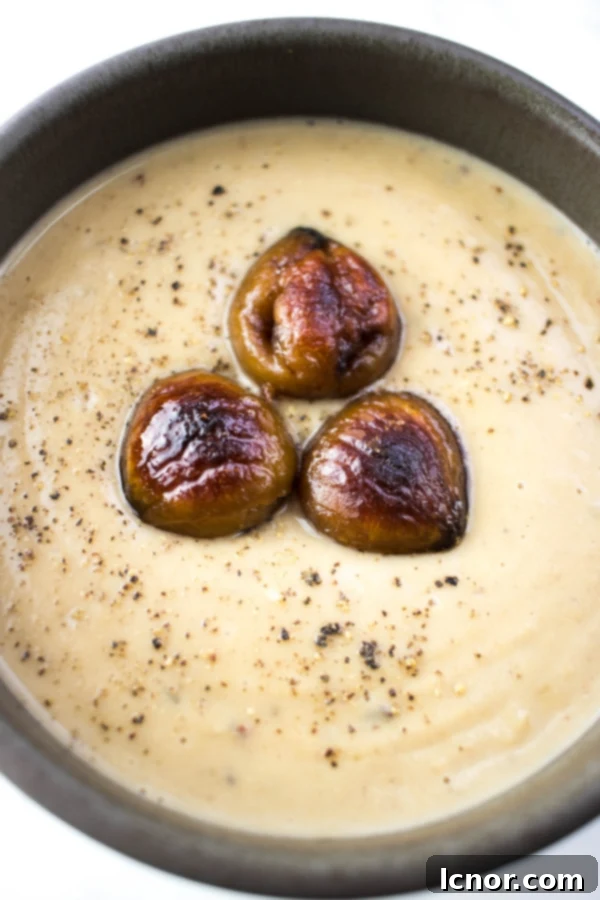 A bowl of creamy French Chestnut Soup garnished with fresh herbs, ideal for a romantic appetizer.