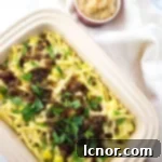 Älplermagronen (Swiss Alpine Macaroni) in a baking dish with applesauce on the side