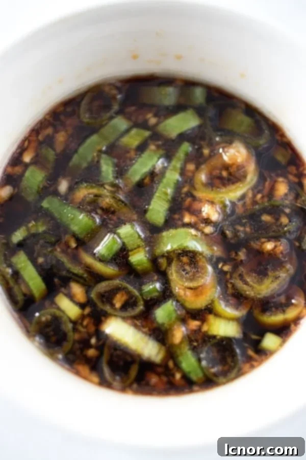 Close-up of freshly made Korean Bulgogi Sauce in a bowl, showing its rich texture and green onion garnish.