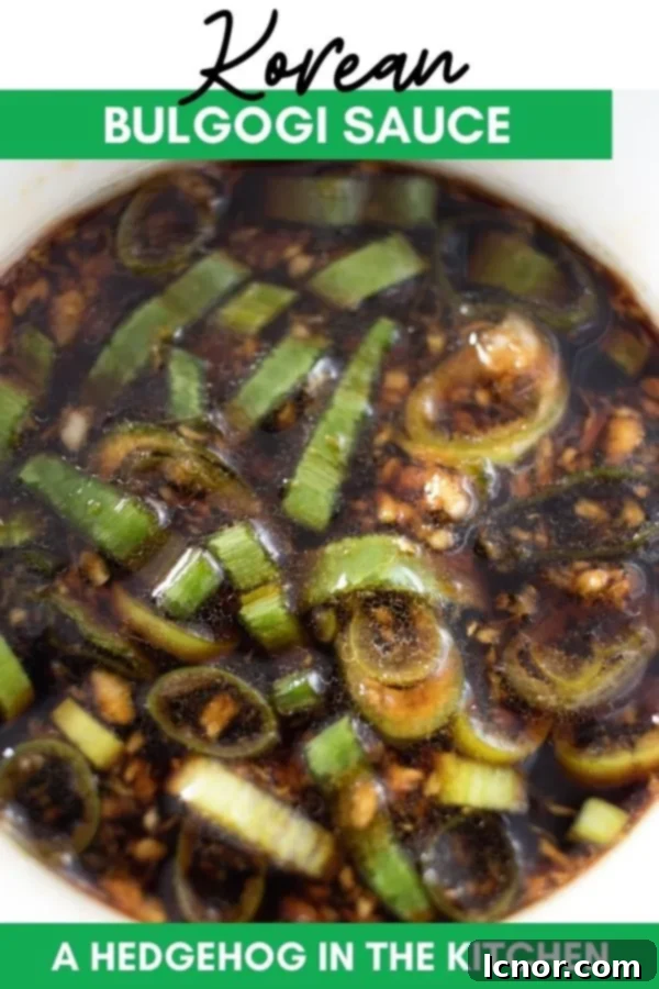 A bowl of Korean Bulgogi Sauce on a wooden background, garnished with sesame seeds and green onions.