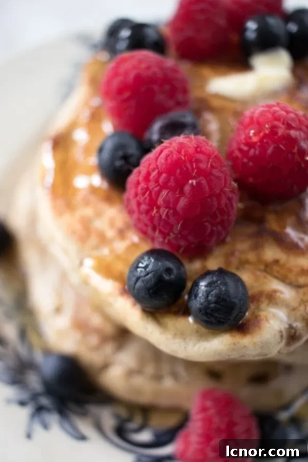 raspberries, blueberries and maple syrup on pancakes