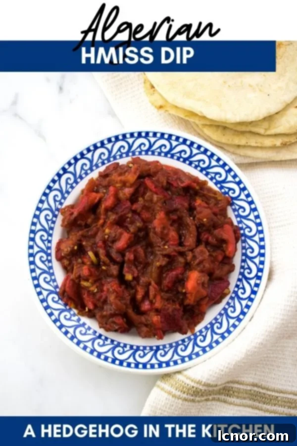 Hmiss (Algerian roasted red pepper and tomato dip) in a bowl with pita bread, perfect for pinning.