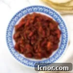 Hmiss (Algerian red pepper dip) on a blue and white plate with pitas