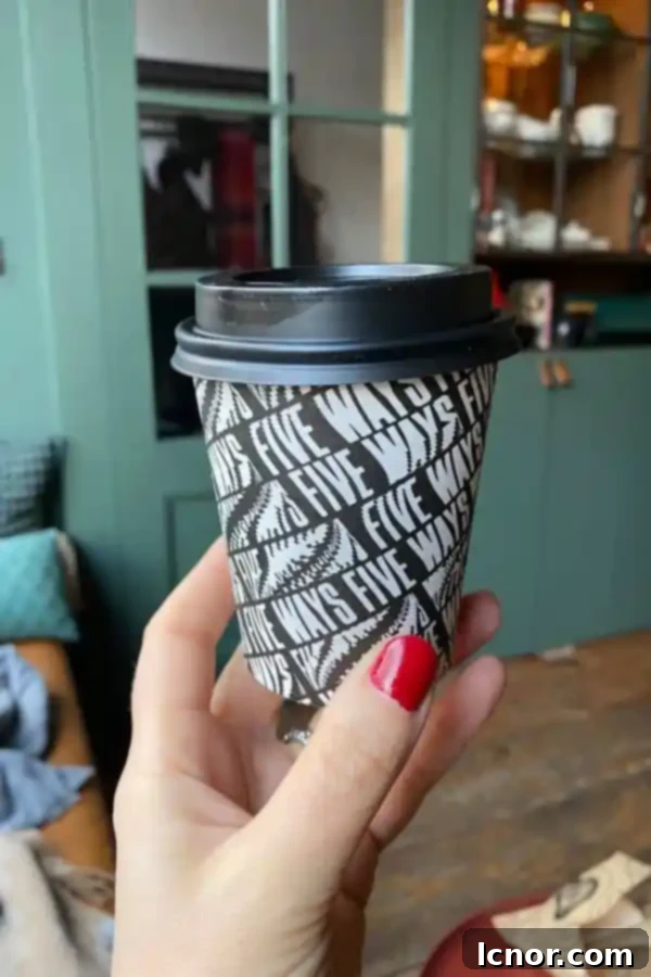Freshly brewed coffee in a to-go cup, ready to be paired with a bagel at Breadwinner Amsterdam.