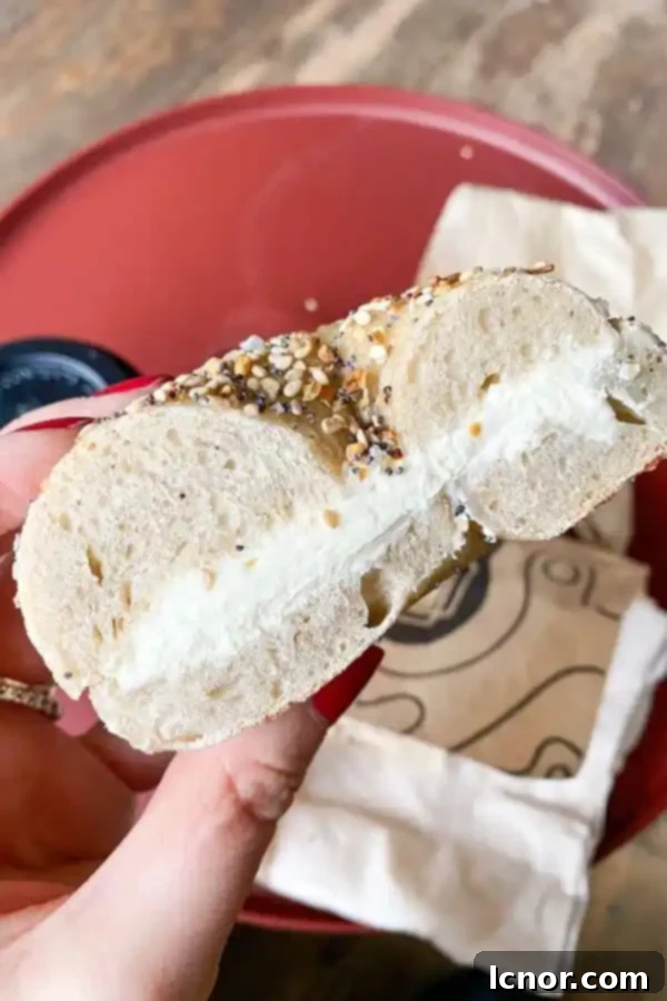 Close-up of a perfectly prepared everything bagel with a generous layer of cream cheese from Breadwinner Amsterdam.