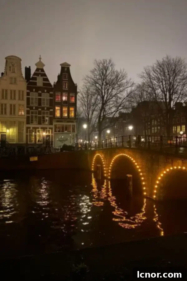 Amsterdam canals decorated with festive Christmas lights, reflecting on the water at night during winter
