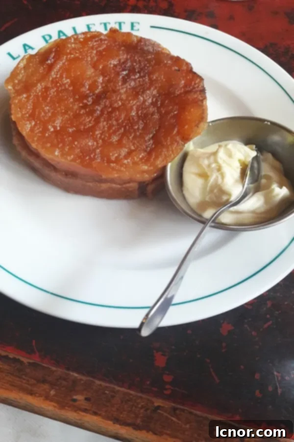 A delicious slice of Tarte Tatin with caramelized apples and flaky pastry.