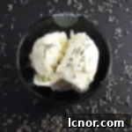 lavender honey ice cream topped with dried lavender with a black background