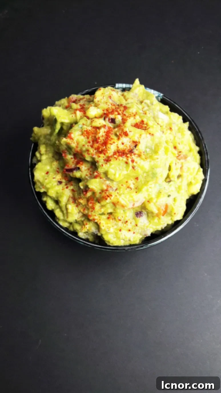 Close-up of freshly prepared sailboat guacamole, garnished with cherry tomatoes and cilantro, showcasing its appealing texture and vibrant colors, ready for an easy boat snack.