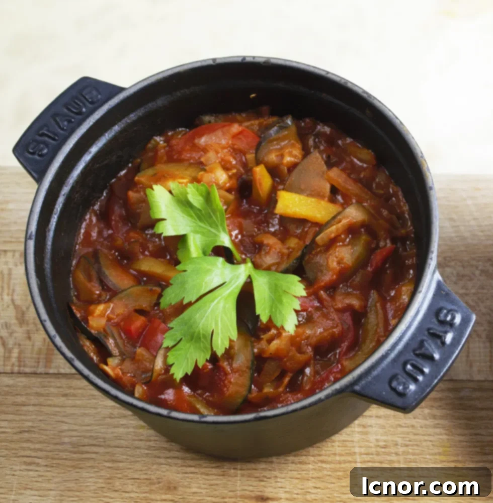 French ratatouille recipe in a Staub cast iron pot topped with a poached egg