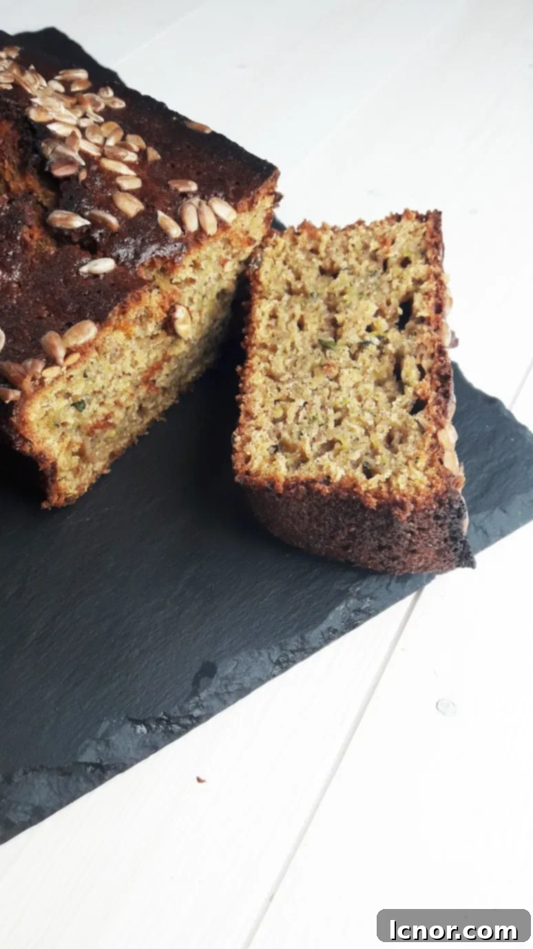 Slice of moist zucchini cake with sunflower seeds on top