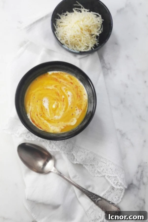 French pumpkin soup with grated emmental cheese and a white and marble background
