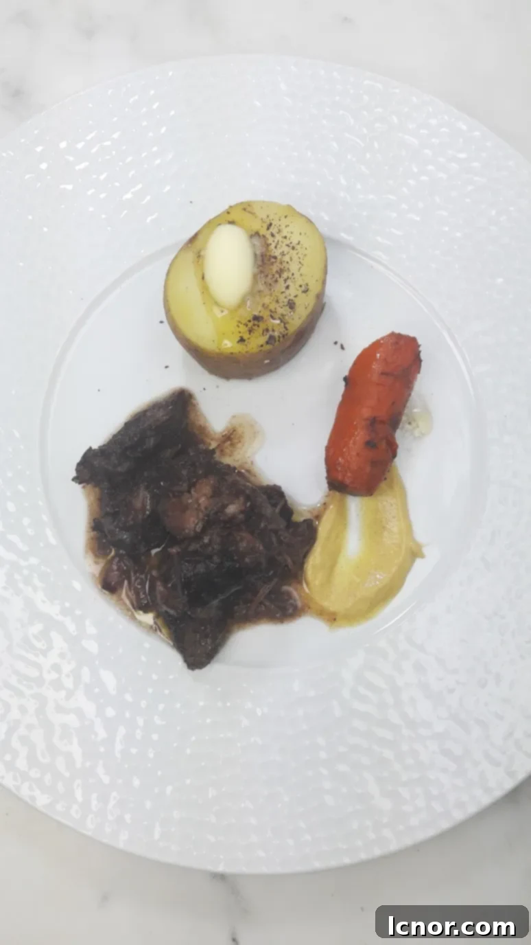 A close-up of a serving of Classic French Boeuf Bourguignon with a side of creamy mashed potatoes.