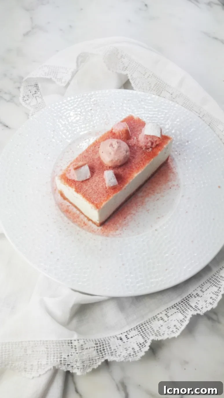 A beautifully plated Biscuits Roses de Reims Cheesecake, showcasing its delicate pink hue.