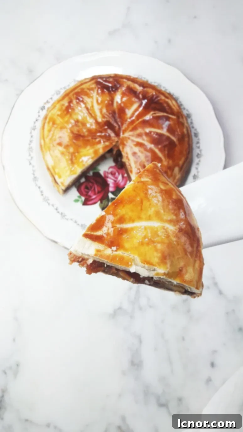 A delectable slice of caramelized apple galette des rois on a plate, ready to be enjoyed. | ahedgehoginthekitchen.com