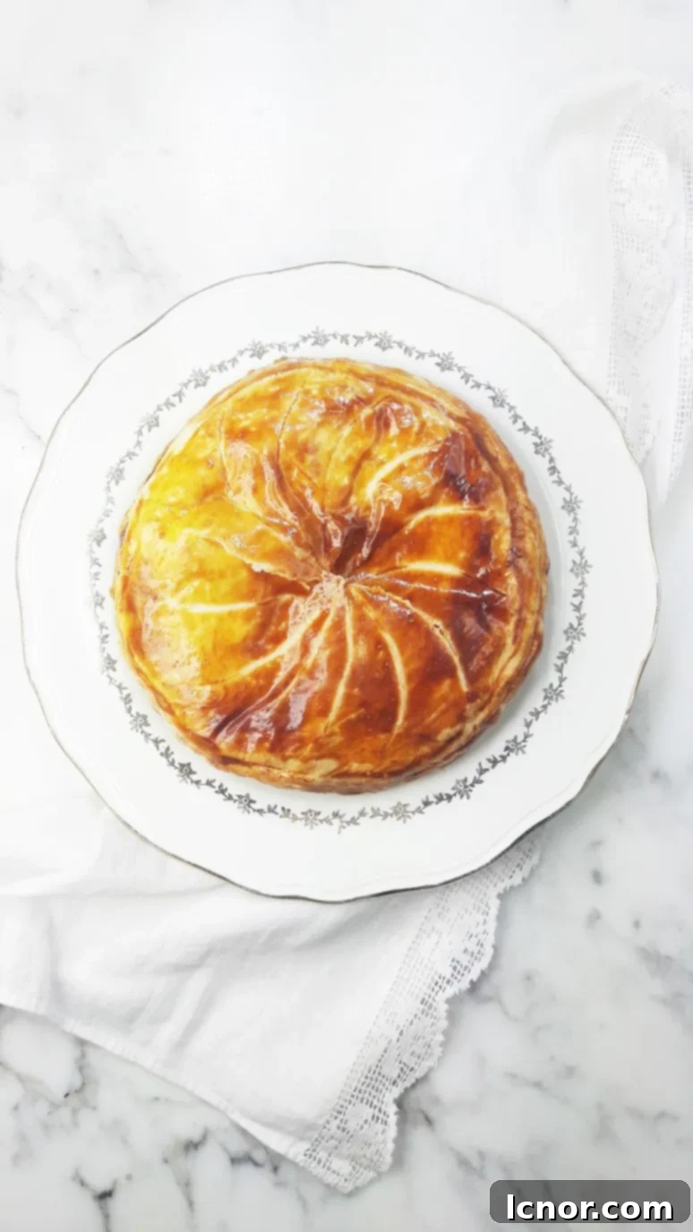 A beautifully scored and baked caramelized apple galette des rois, ready to be sliced. | ahedgehoginthekitchen.com