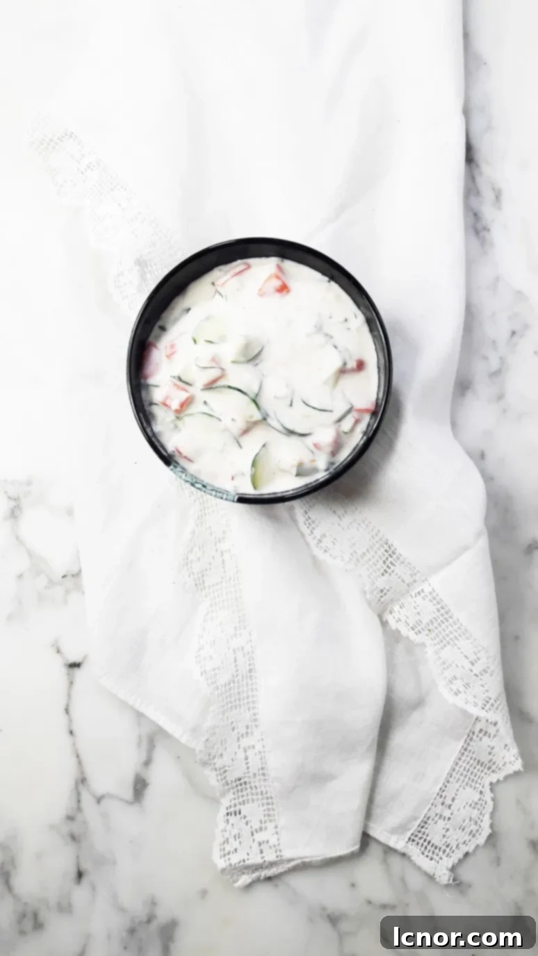 Indian yogurt, cucumber and tomato raita recipe. This is so delicious served with carrot sticks as an appetizer or as part of an Indian feast served with curries and naan bread.