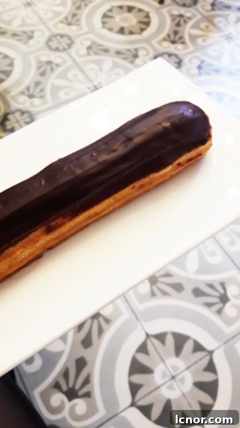 The delectable chocolate éclair from Paris Baguette, captured with its smooth, glossy finish, perfect for a sweet indulgence.
