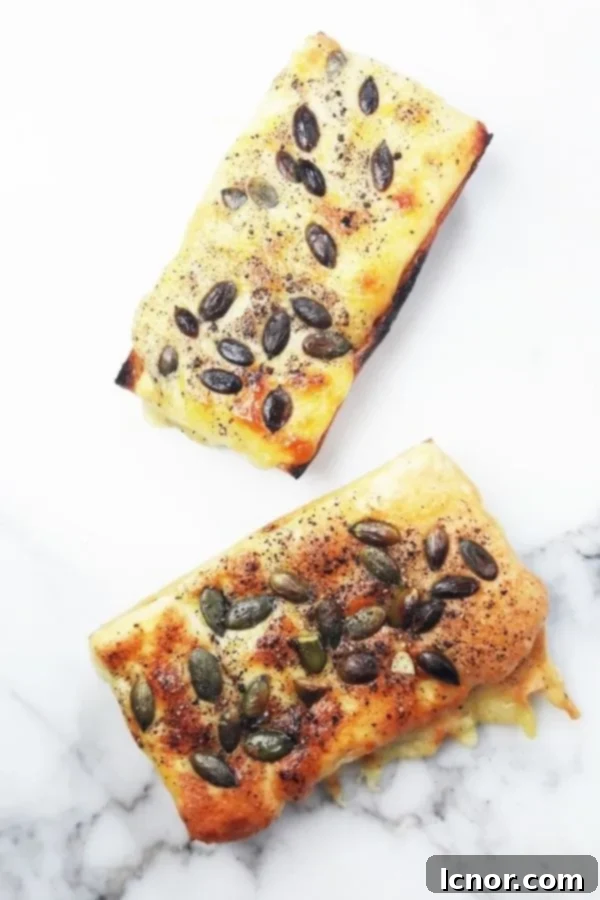 Crispy cheese toast on a sliced French baguette, adorned with golden melted cheese and vibrant green pumpkin seeds, ready to be served as a soup companion.