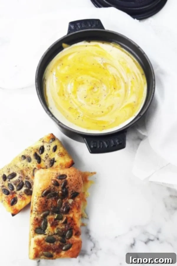 Crispy cheese toast on a baguette slice alongside a rustic pot of creamy pumpkin soup, illustrating a perfect meal pairing for cozy dining.