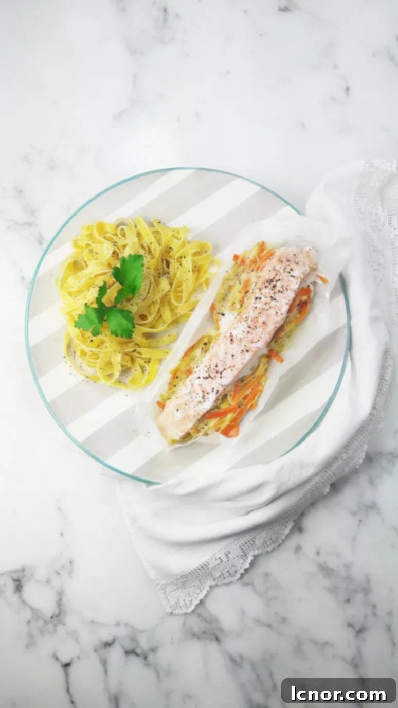 Perfectly baked salmon with leeks and carrots in parchment paper, showcasing the moist, flaky fish and tender vegetables. A healthy and easy French-inspired recipe for dinner.