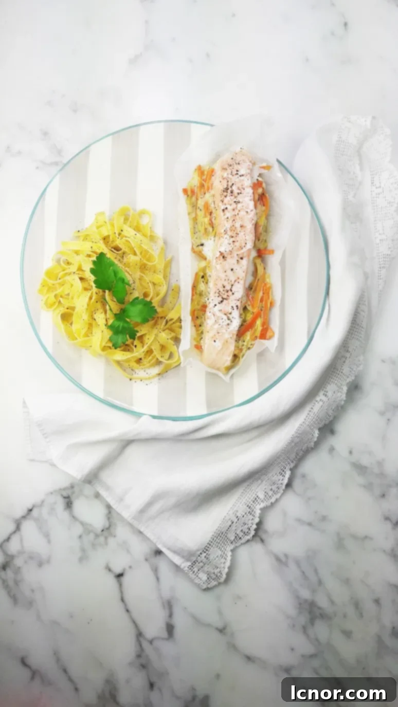 A freshly opened parchment paper packet revealing the perfectly cooked salmon, leeks, and carrots, ready to be enjoyed.