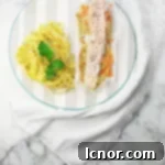 A freshly opened parchment paper packet revealing the perfectly cooked salmon, leeks, and carrots, ready to be enjoyed.