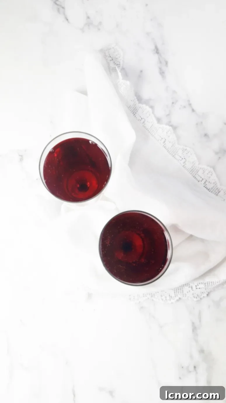 Two glasses of Kir Breton, a fruity and sparkling blackcurrant and apple cider cocktail, ready to be enjoyed.