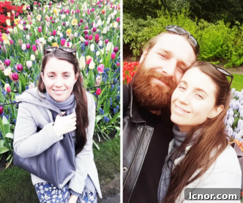A couple smiling in front of a colorful flower bed at Keukenhof.