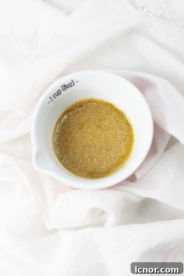 Tasty French salad dressing in a glass container with a spoon