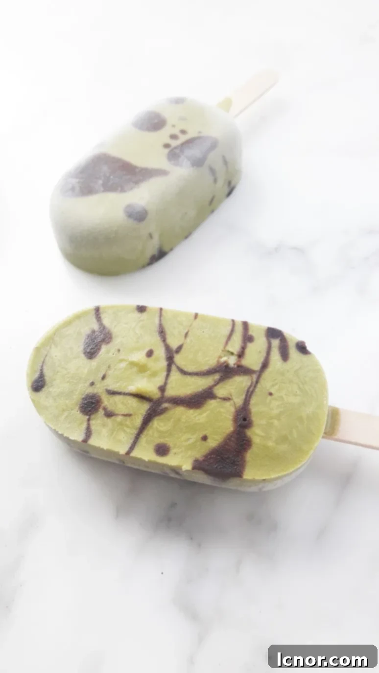 Sugar-free matcha chocolate popsicles. A close-up showing the distinct matcha and chocolate layers and swirls.