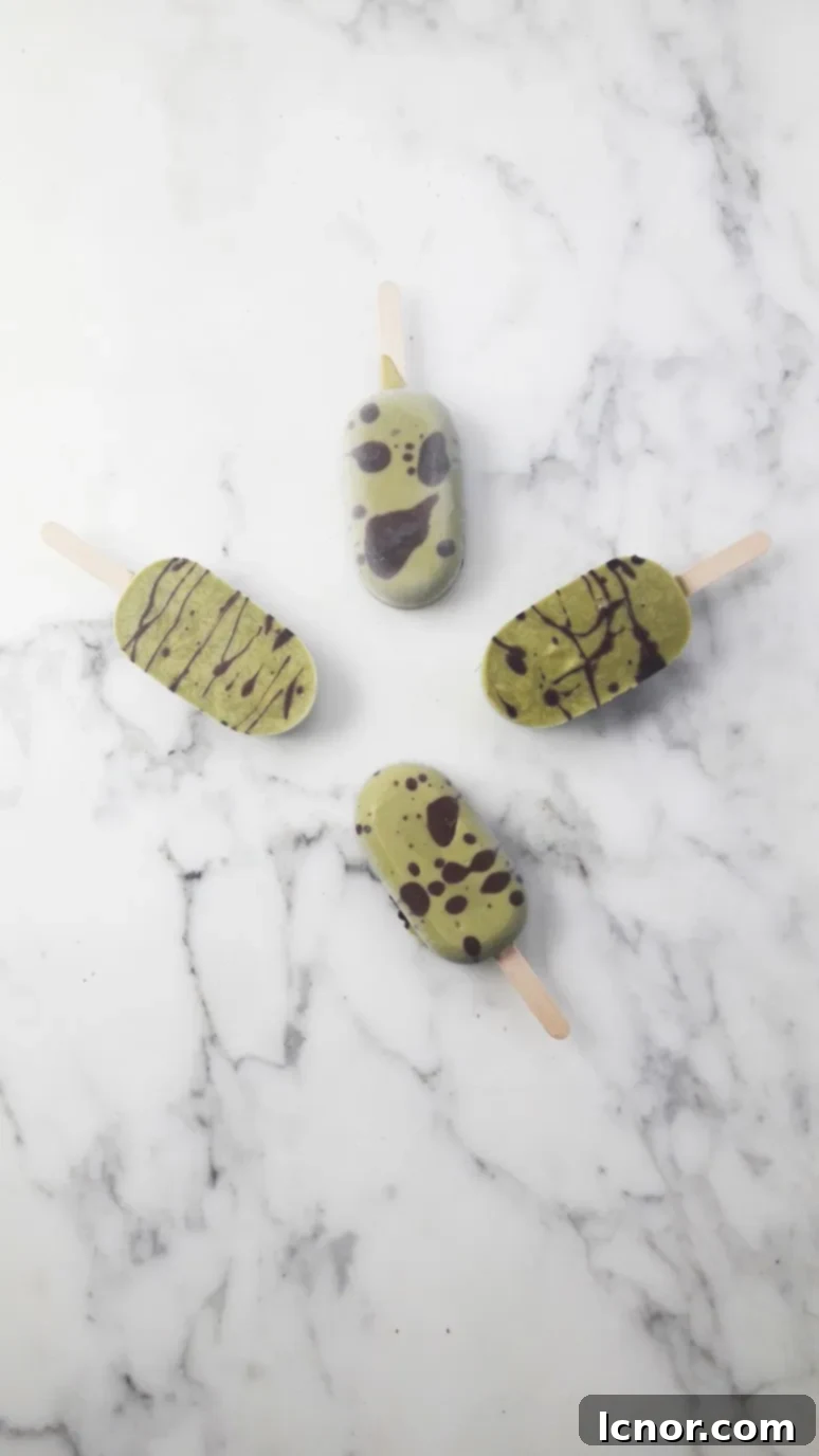 Sugar-free matcha chocolate popsicles. Another angle of the vibrant green popsicle with chocolate streaks.