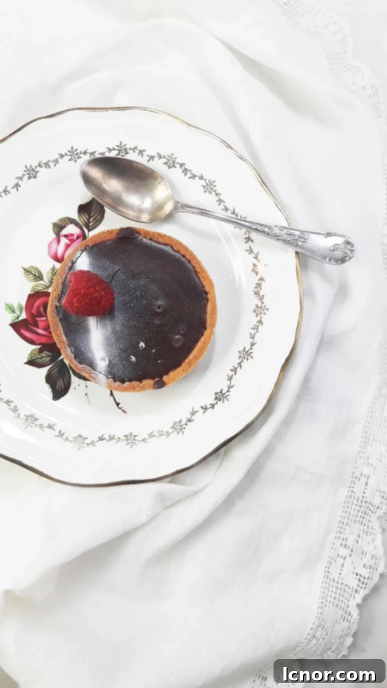 Rich organic chocolate shortbread tart with a fresh raspberry from Panifica Bakery, a must-try in Paris. | ahedgehoginthekitchen.com