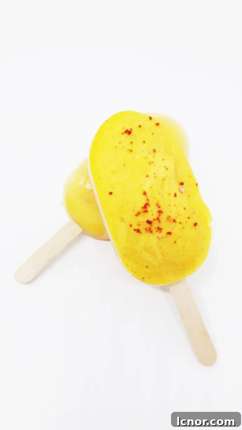 Delicious Mango Lassi Popsicles – a perfect blend of sweet mango, creamy Greek yogurt, and a touch of spicy pepper for a refreshing summer treat. | ahedgehoginthekitchen.com