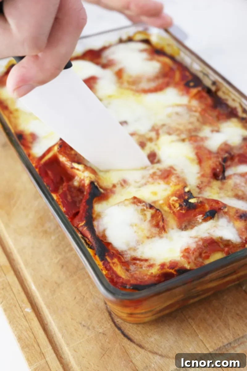 Close-up of a slice of Roasted Eggplant Lasagna, showing layers of vegetables and cheese, ahedgehoginthekitchen.com