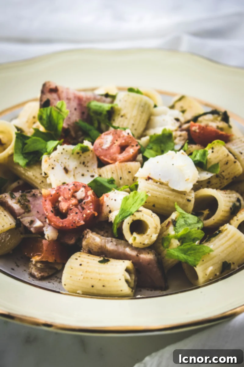 Close-up of delicious fish pasta with cod, tuna pastrami, tomatoes, and parsley